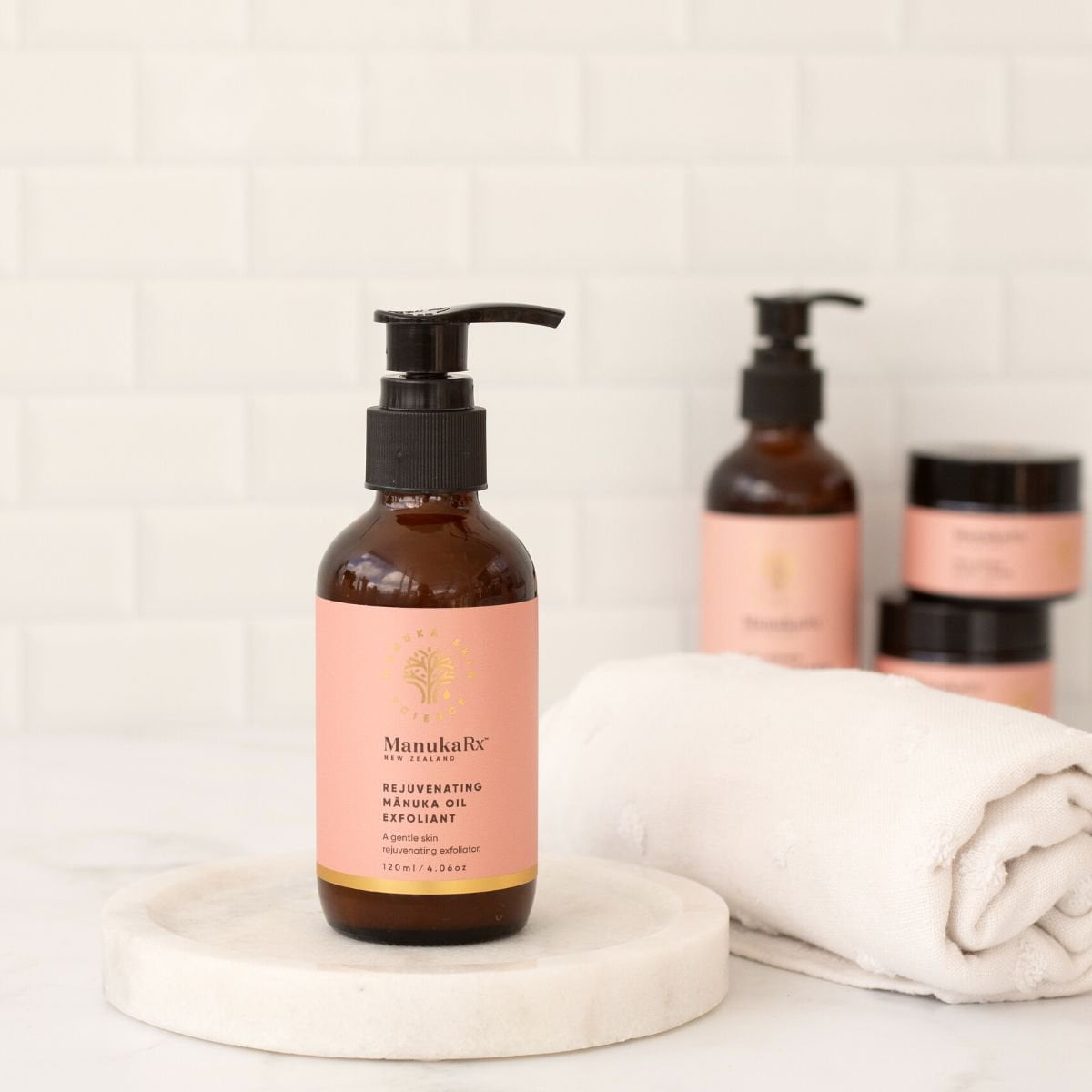 Rejuvenating Manuka Oil Exfoliant bottle on white dish in bathroom