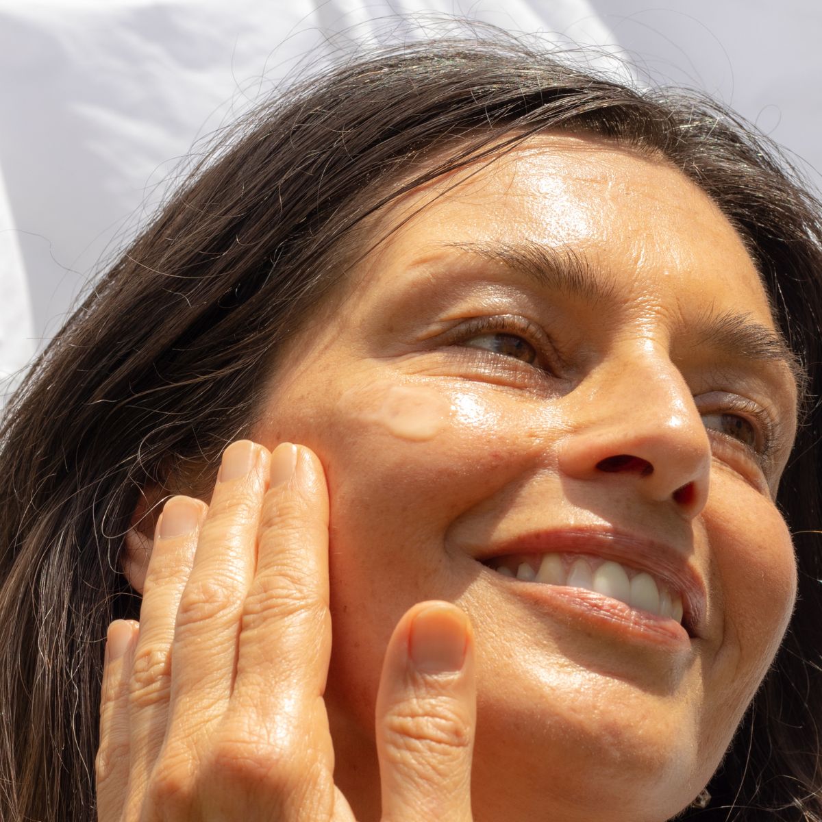 Woman applying ManukaRx Skin Brightening Vitamin C Serum to her face