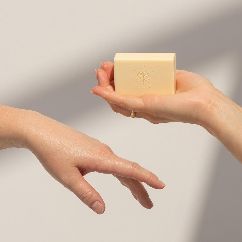 Hands holding a bar of ManukaRx Extra Gentle Cleansing Soap