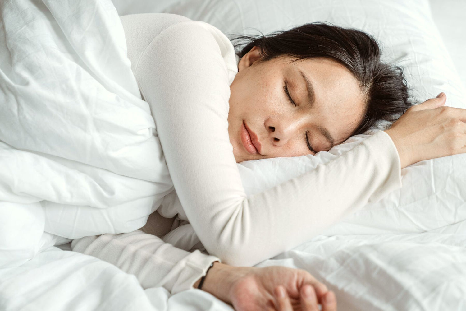 A woman peacefully sleeping in a cozy bed.