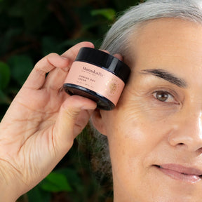A woman holding a pot of Firming Day Cream